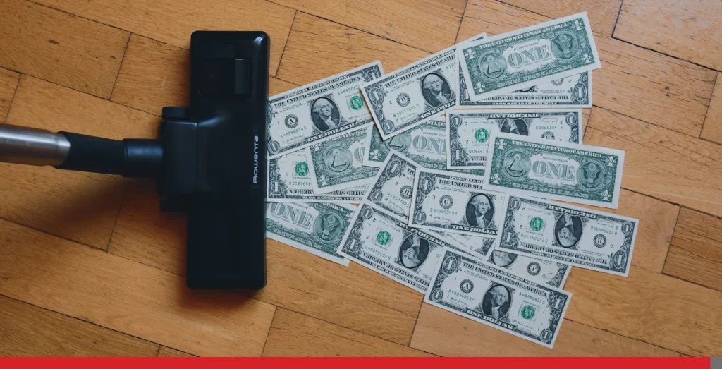 Vacuum cleaner with dollar bills on the floor