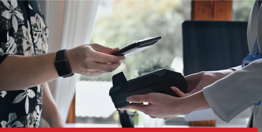 Customer scanning his smartphone to make contactless payments at a coffee shop.