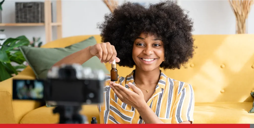 Cheerful black woman recording video. Skin care.