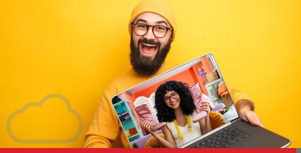 Bearded man with a yellow hat holding a laptop and smiling