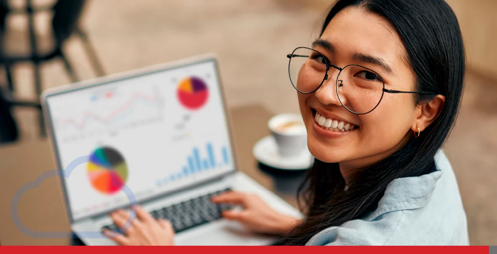 Woman smiling as she works on charts on her laptop