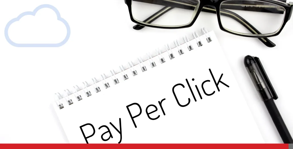 Reading glasses and notebook with word Pay Per Click on a white background.