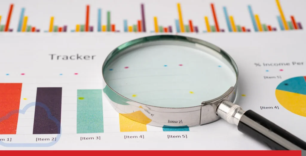 Magnifying glass on charts graphs paper.