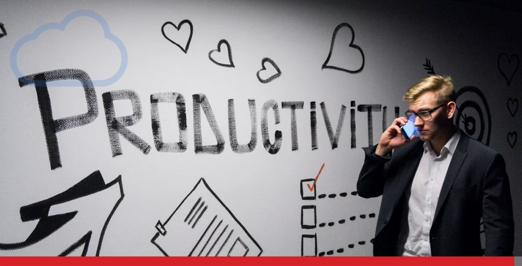 A man stands by a large whiteboard which has productivity written across it