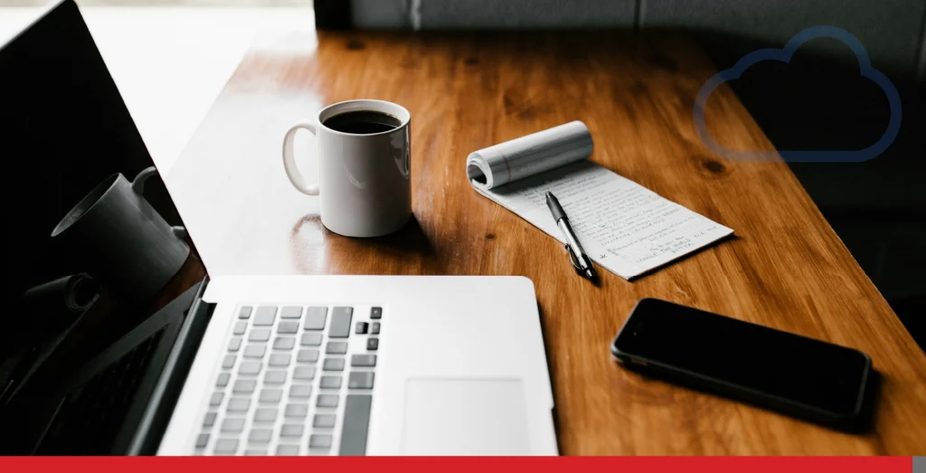 A desk with a laptop and writing pad