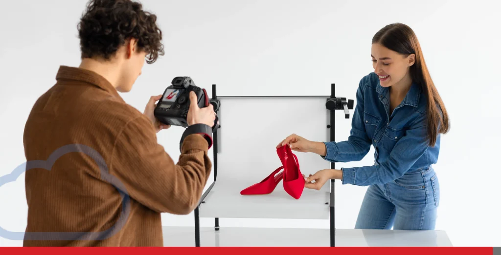 Professional male photographer and female assistant doing content photoshoot for shoes, working in